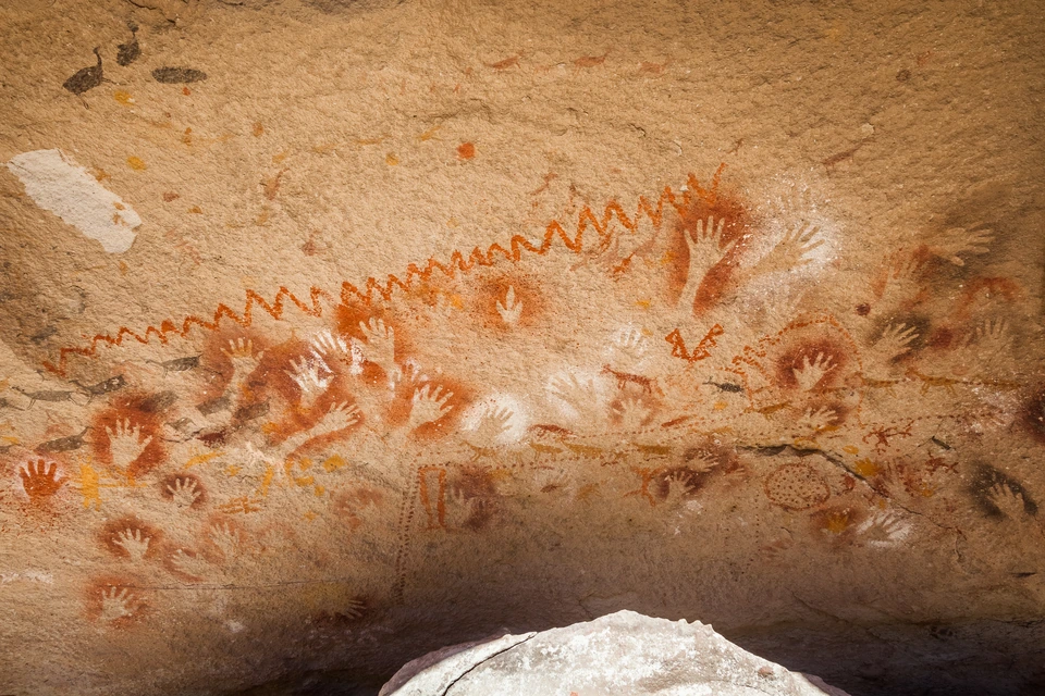Handnegative und verschiedenfarbige Felsbilder in Cueva de las Manos