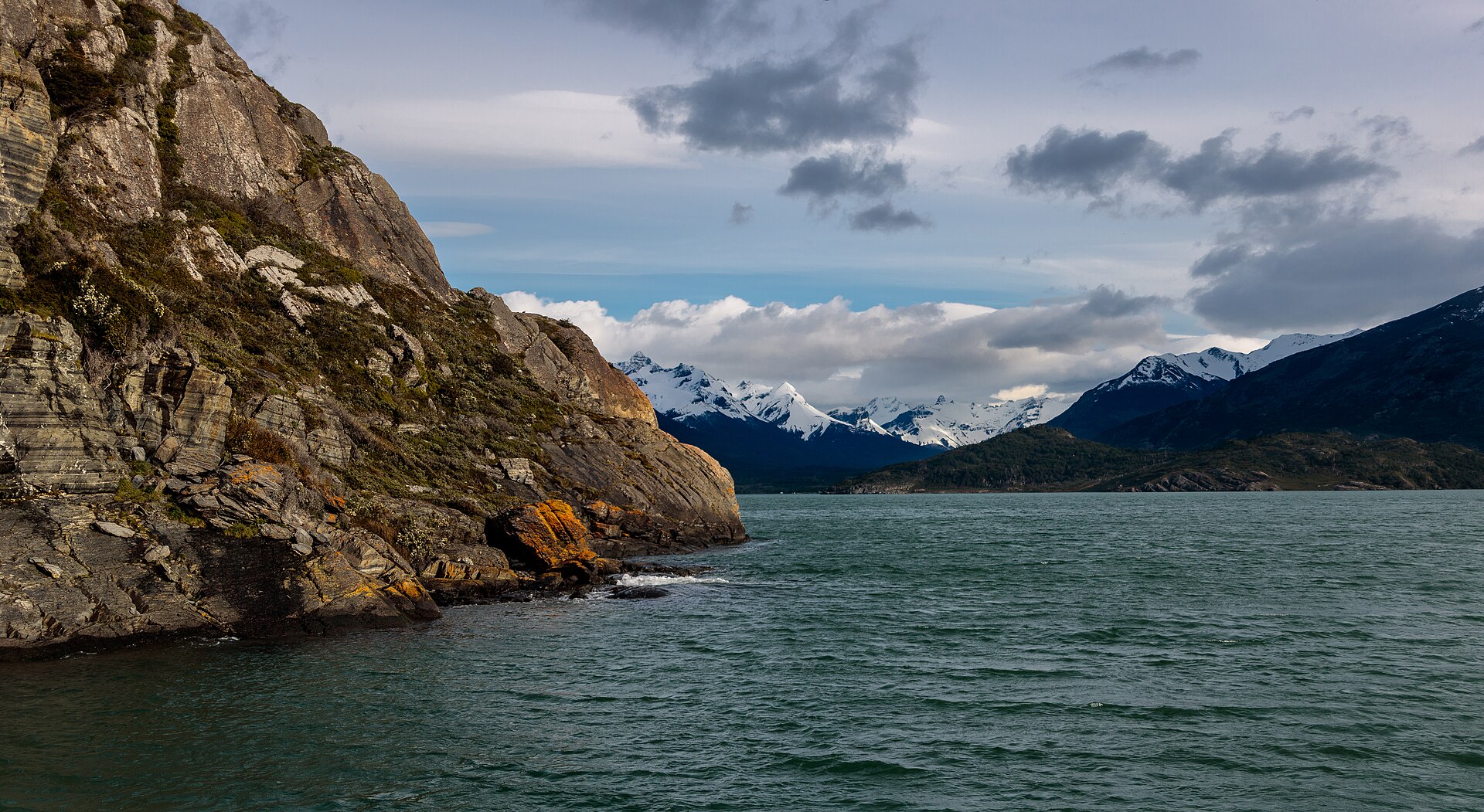 Fiordo patagónico entre roca y montañas nevadas